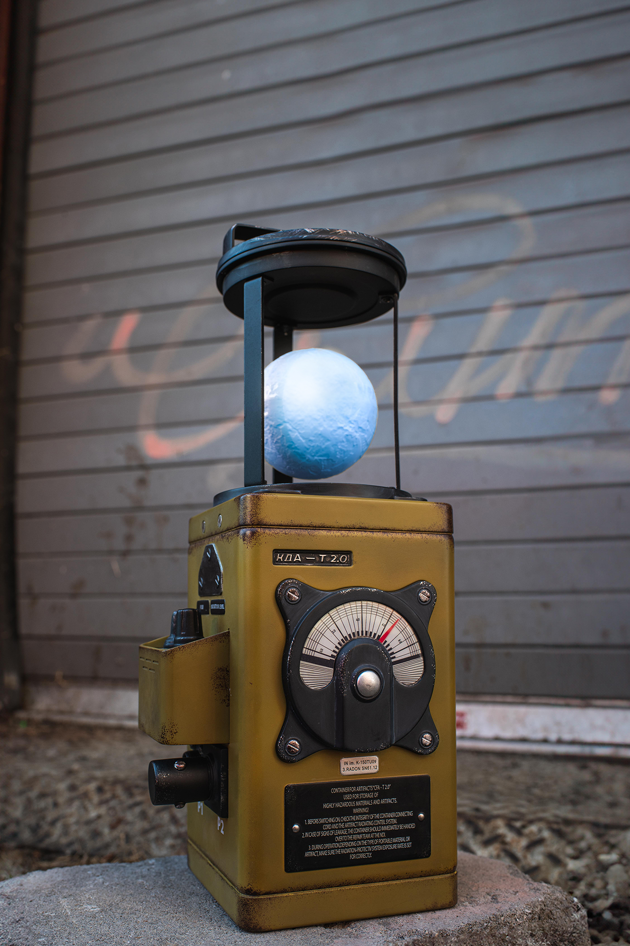 Vintage-style lantern with a blue light bulb against a textured wall.