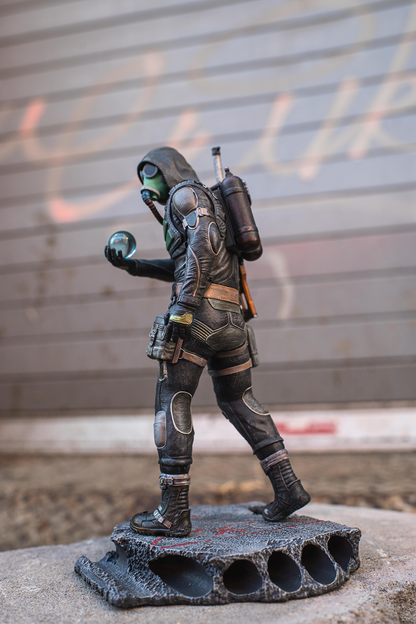 Figurine of a character in a futuristic suit with a backpack on a concrete surface.